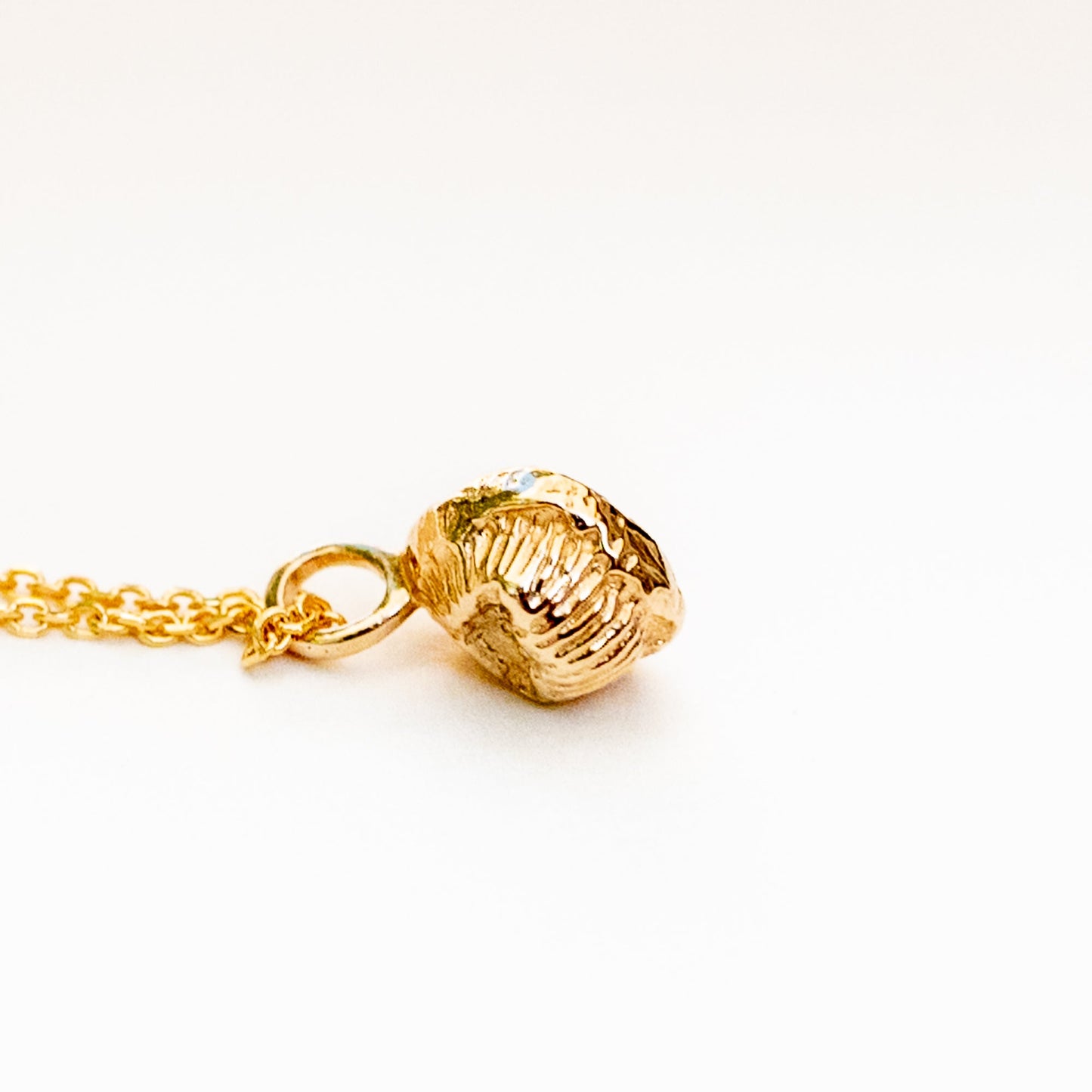 Model neck wearing 14K gold coral polyp necklace with layering potential