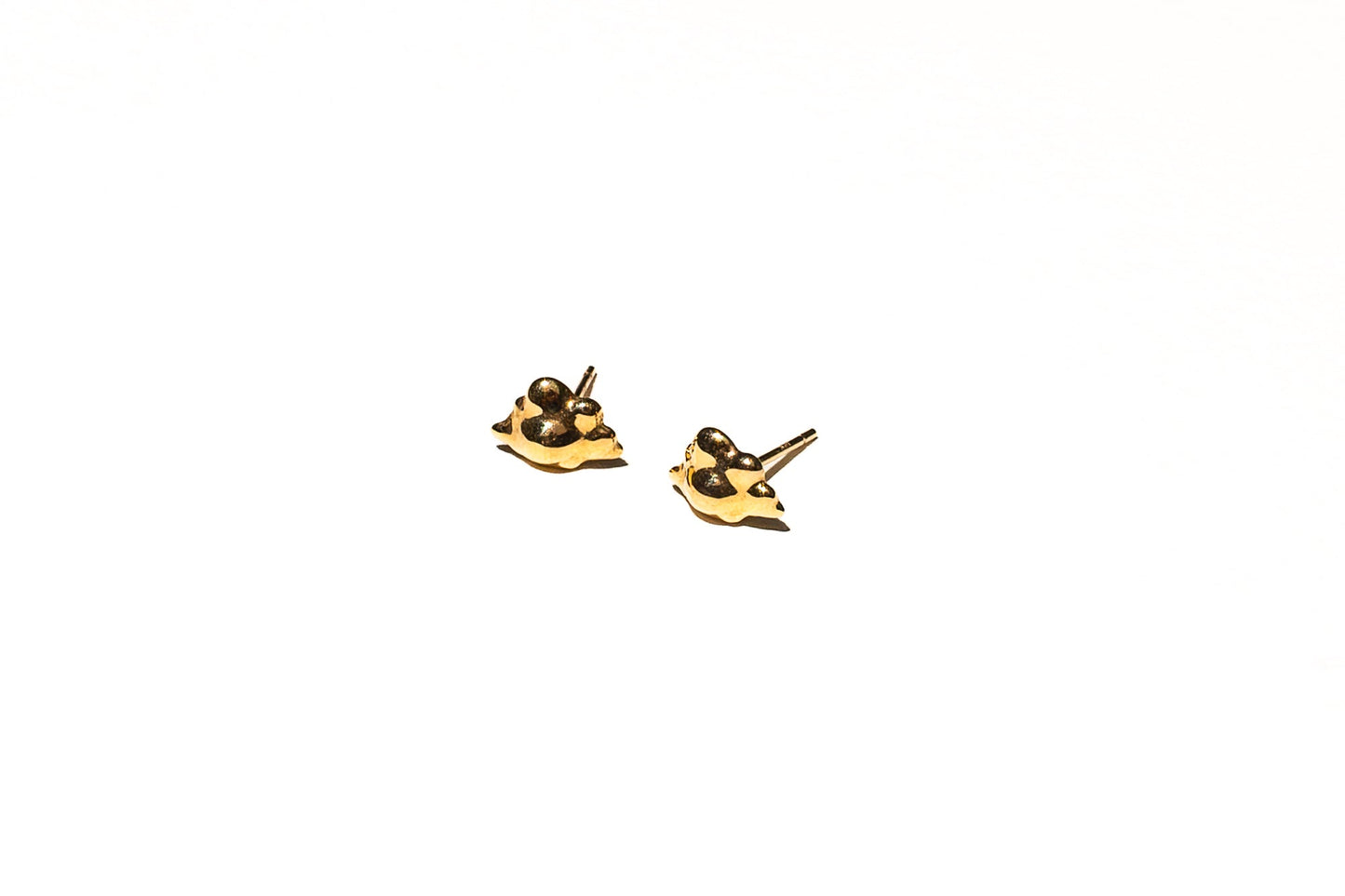 Model ear wearing gold nebulous stud earrings with ethereal quality