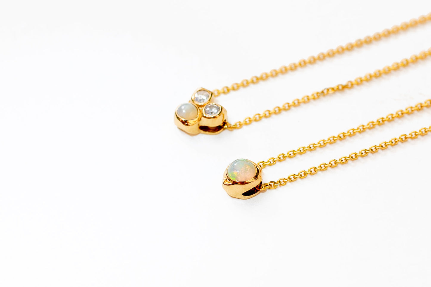 14K gold sculptural opal pendant catching light on model