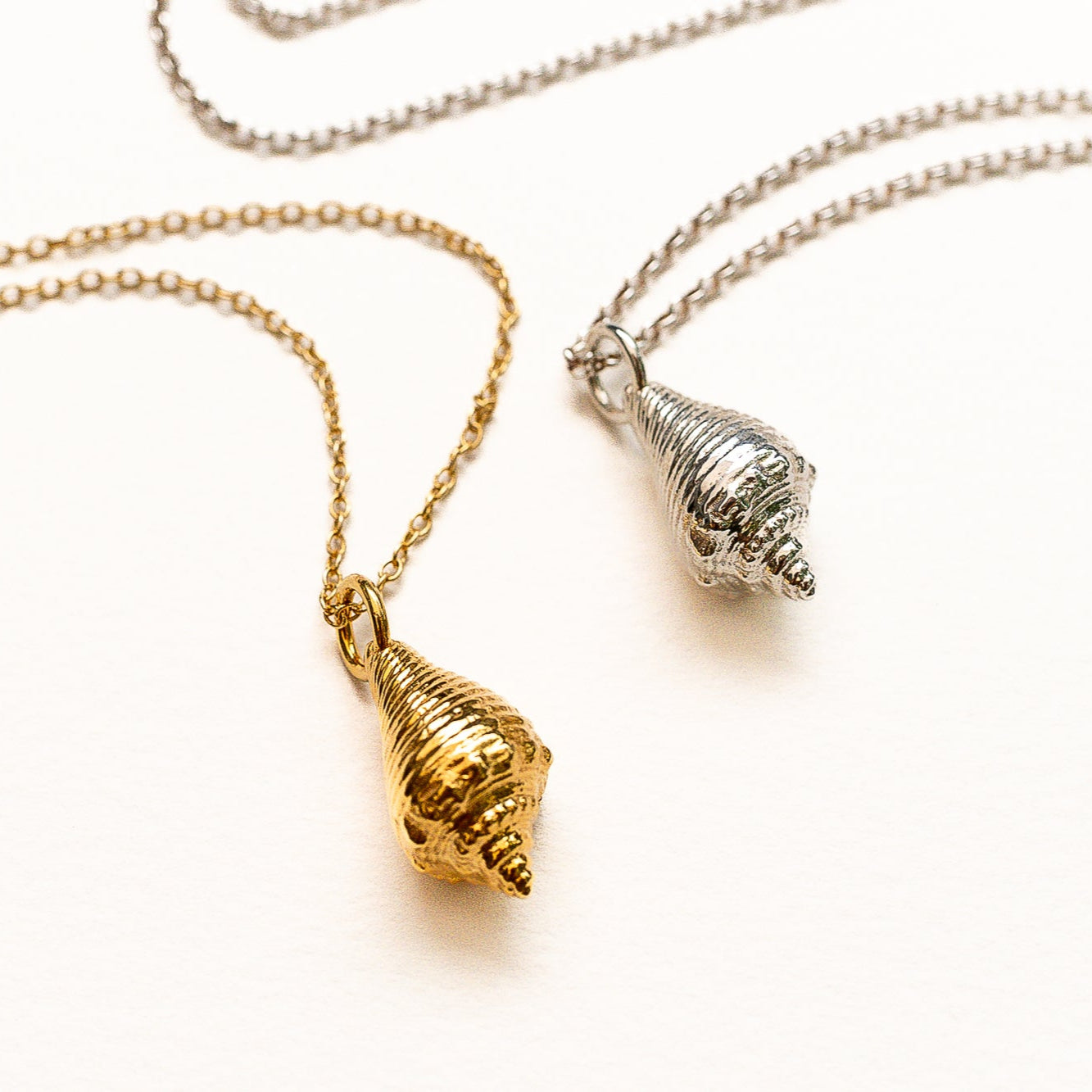 Close-up of sculptural gold vermeil conch pendant showing organic shell detail