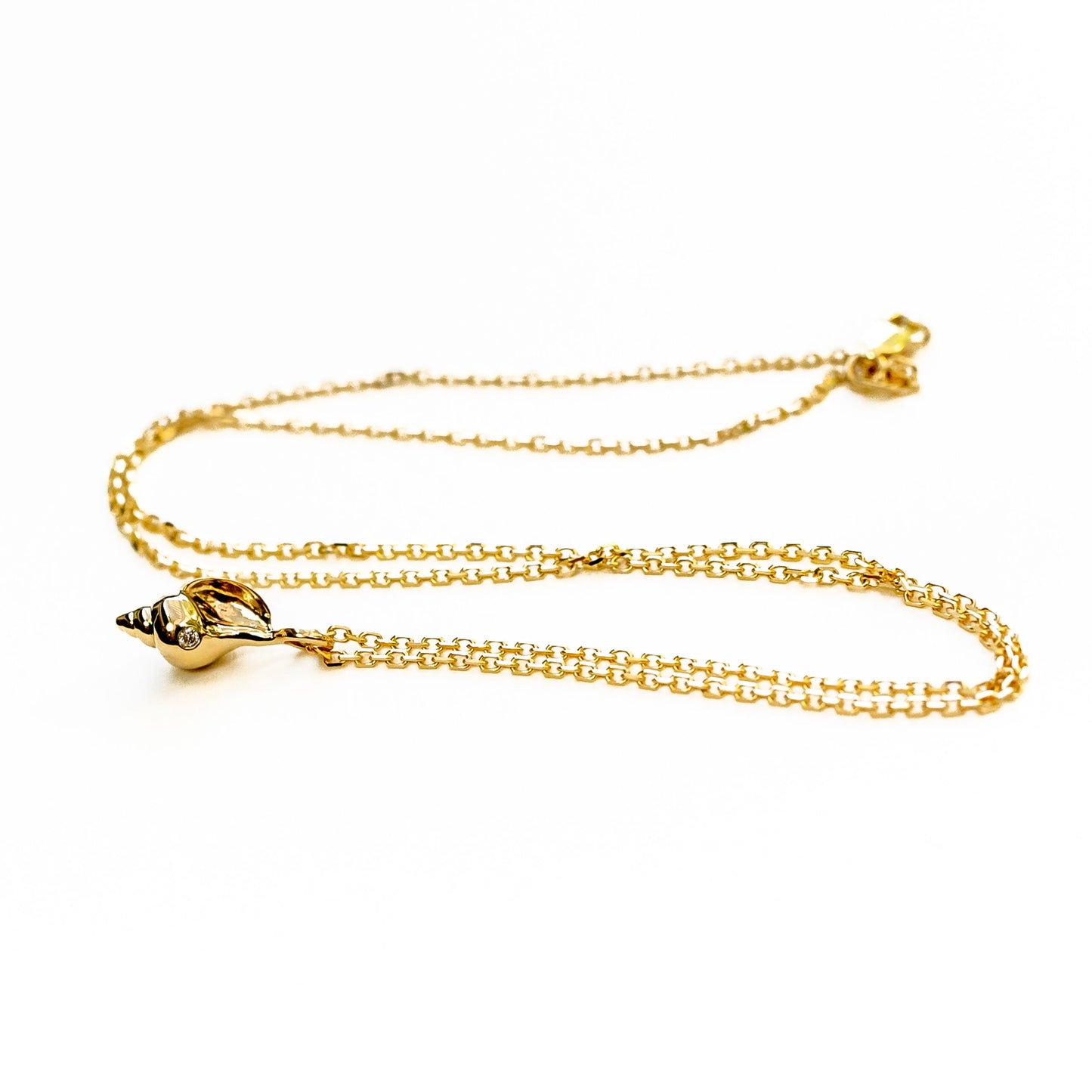 Side view of 14K gold tulip shell necklace displaying organic sculptural form