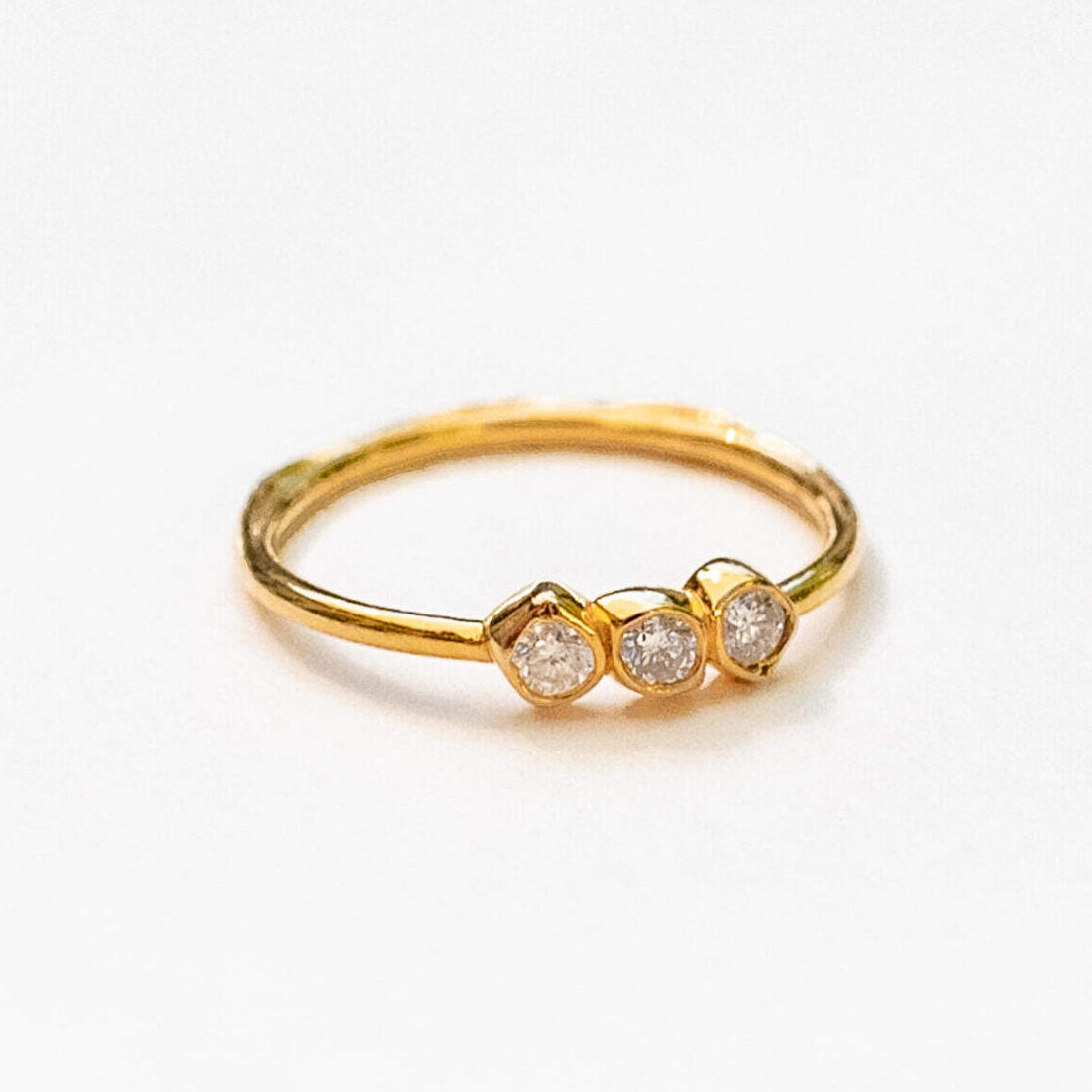 Close-up of three natural diamond configuration showing sea stone inspired mounting