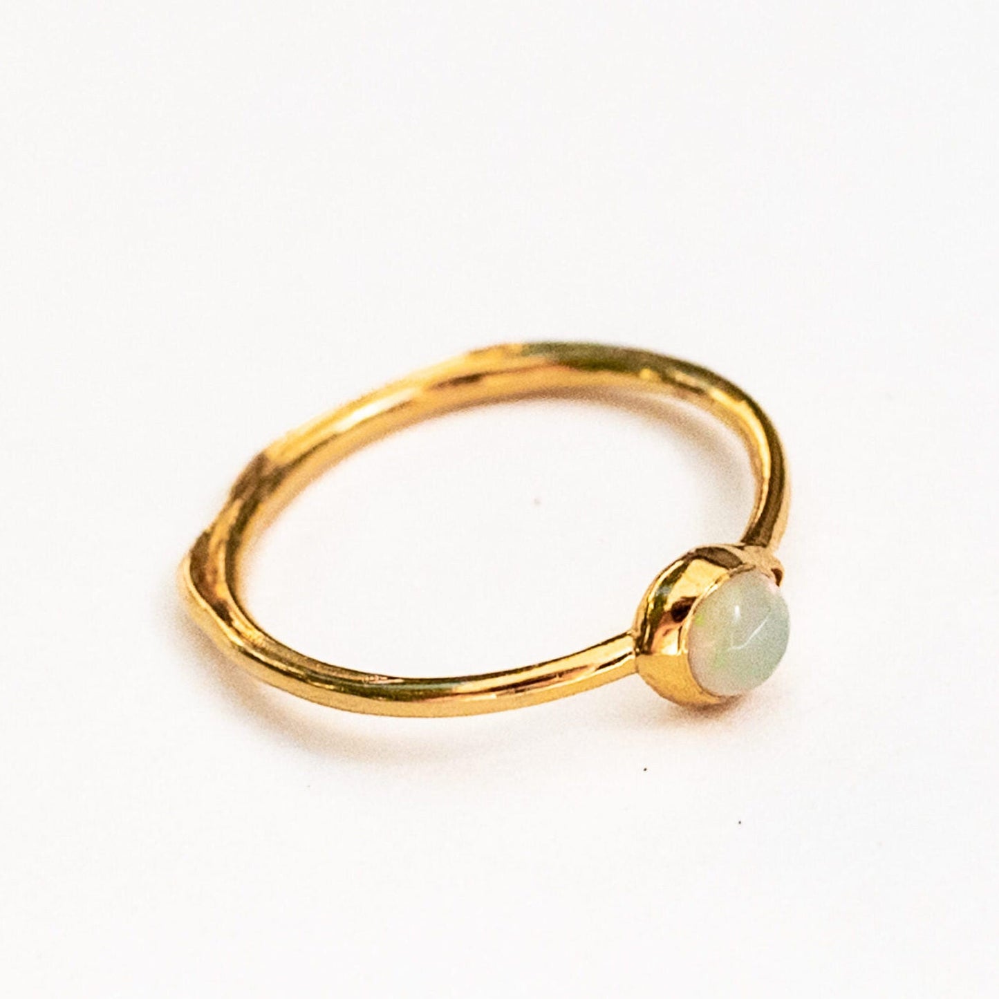 Detail of sculpted water line band design echoing ocean patterns in 18K gold