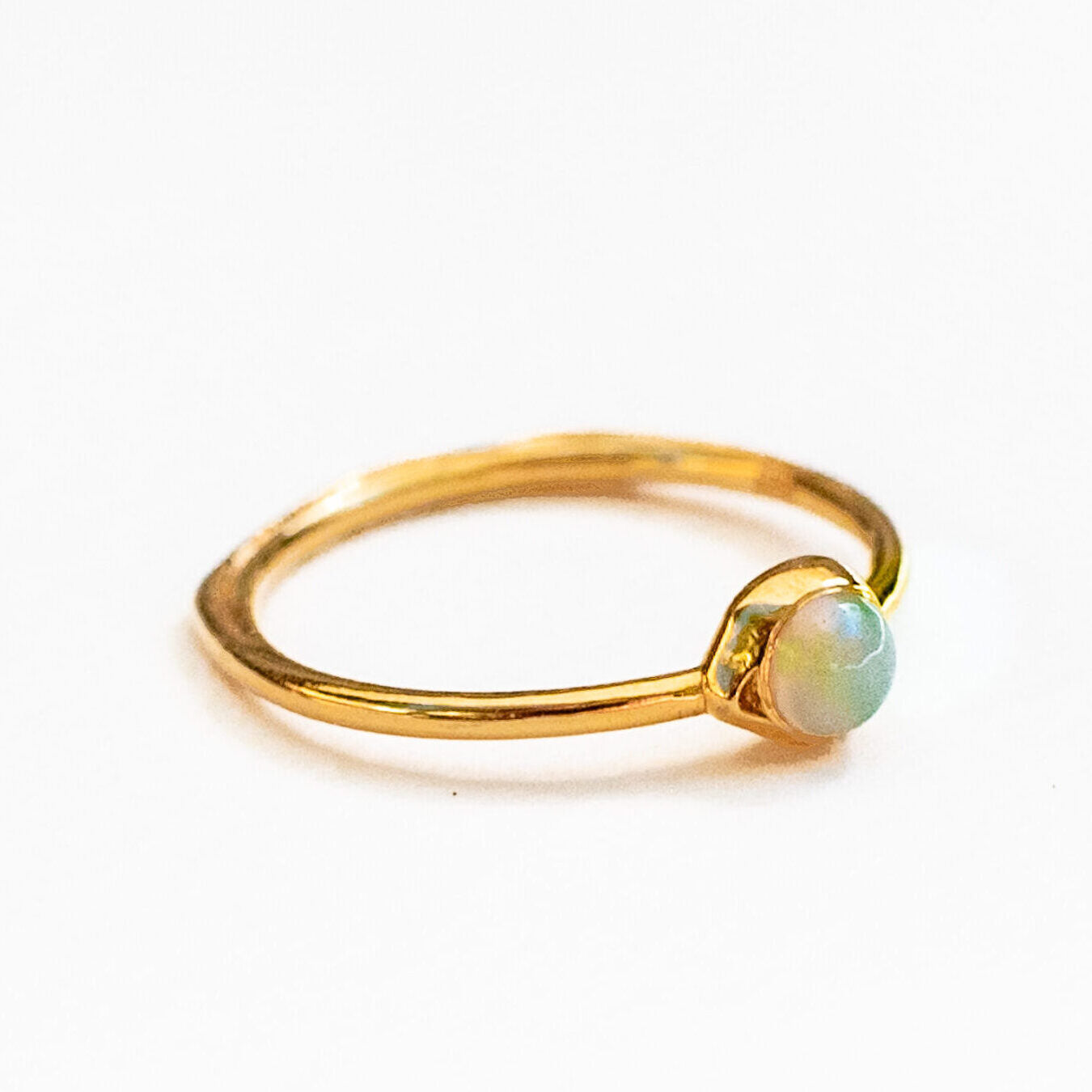 Close-up of natural opal showing play of color and iridescence in water line setting