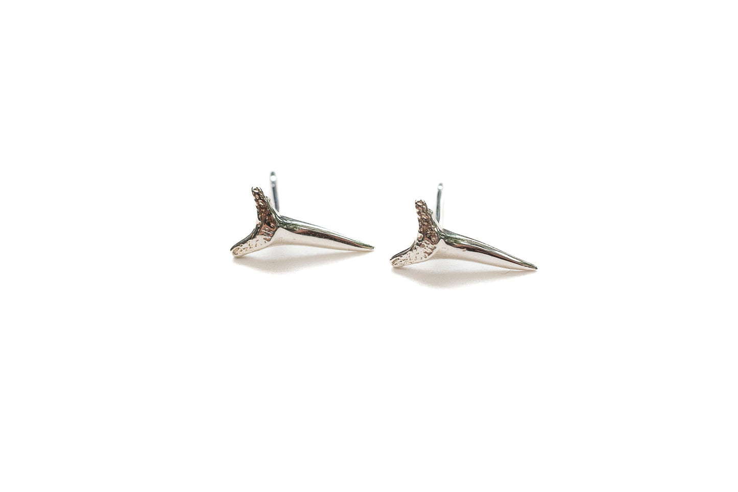 Close-up of sterling silver apex stud earrings showing high-polish finish