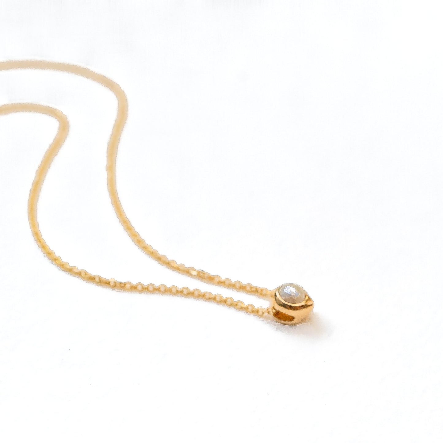 Side profile of oceanus pearl necklace demonstrating delicate chain and pendant