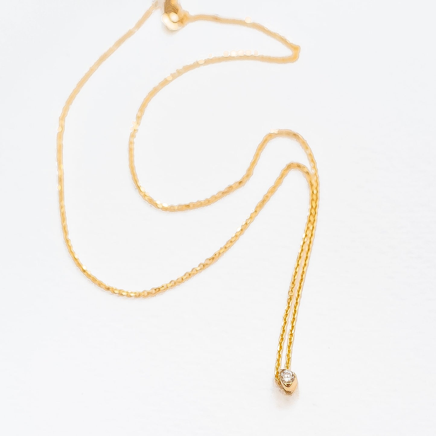 Close-up of adjustable slide mechanism and gold chain with diamond pendant