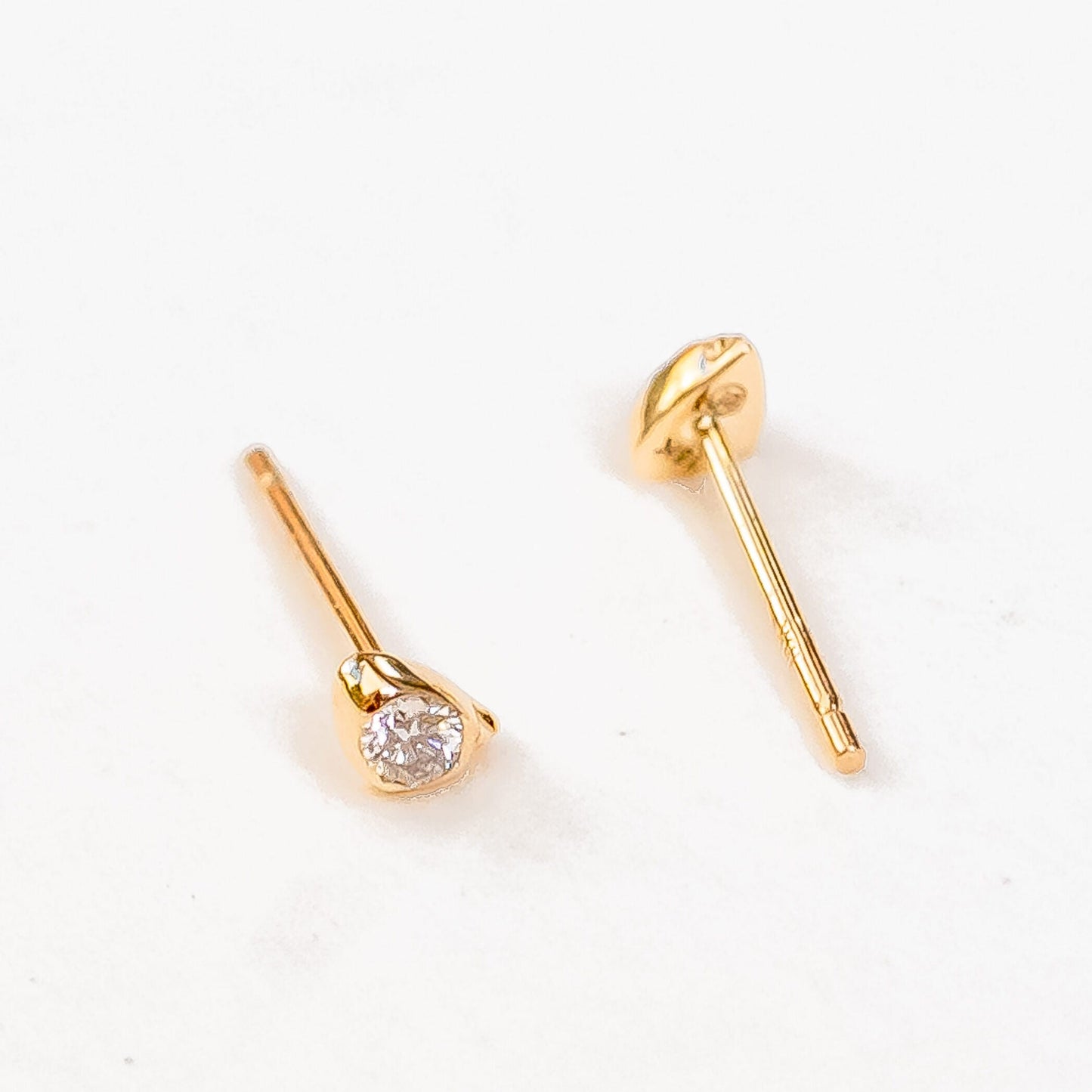 Model ear wearing 14K gold sea stone diamond studs, luxury jewelry detail